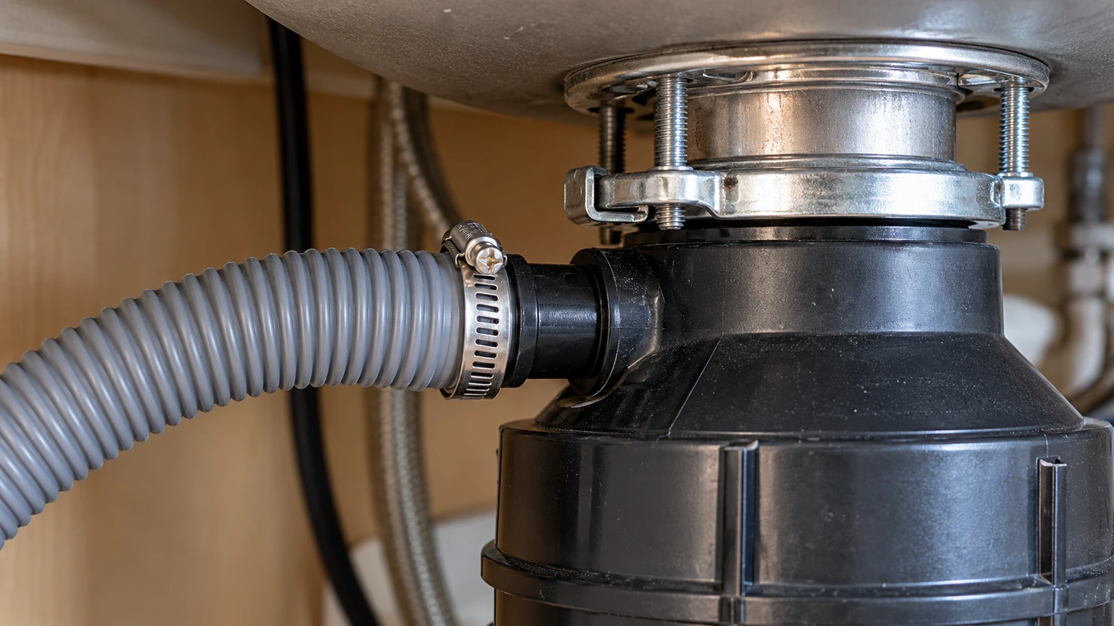 Dishwasher drain hose clamped to the upper inlet of a garbage disposer
